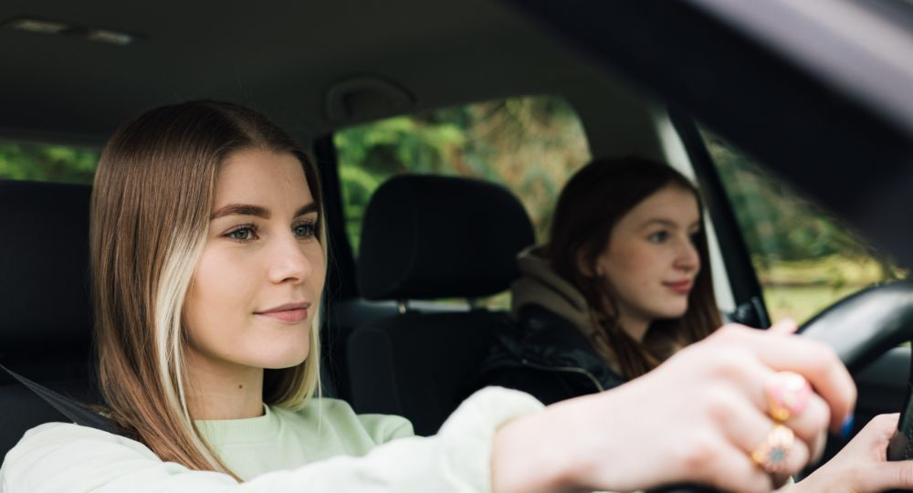 New driver at the wheel of the car with her friend in the passenger seat