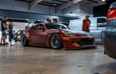 Image of red modified car in a showroom with people around