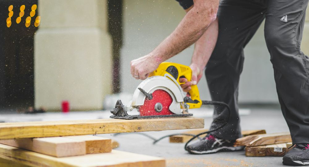 person using a power saw on a plank of wood