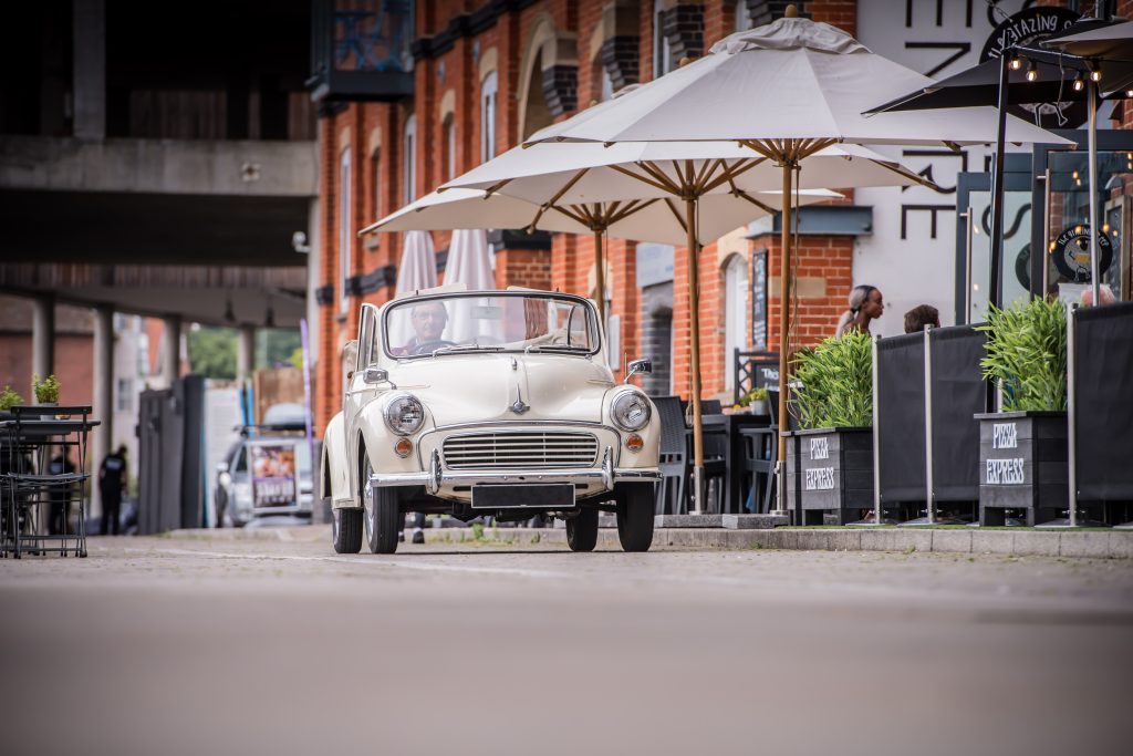 Morris Minor car driving down road