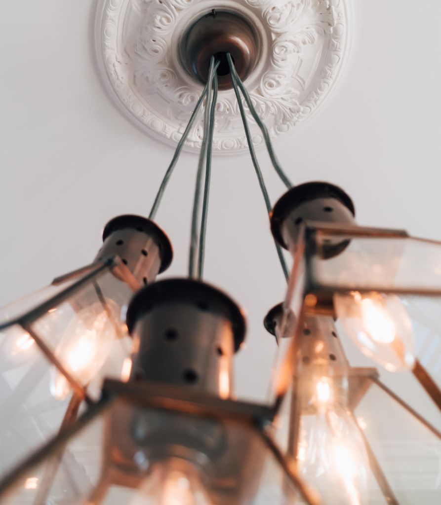 Chandelier hanging from ceiling with Victorian mouldings