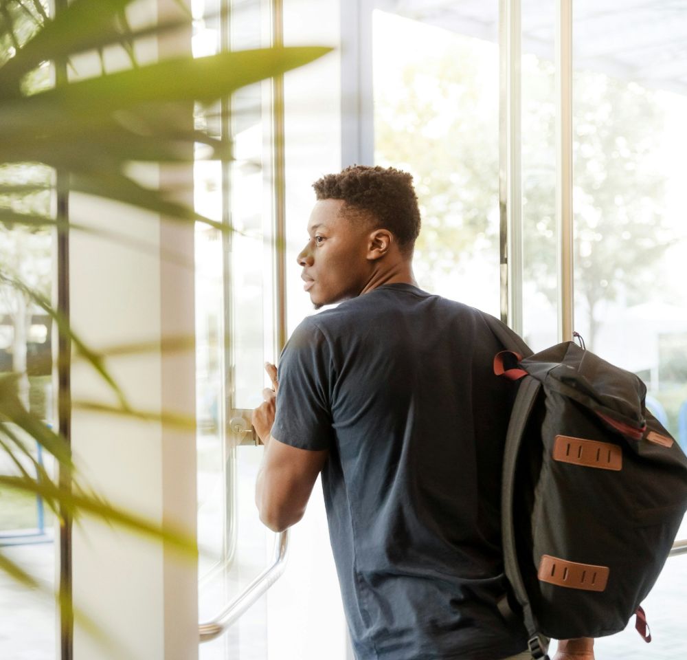 Student wearing backpack leaving halls