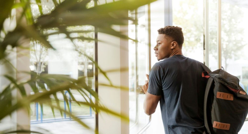 Student wearing backpack leaving halls