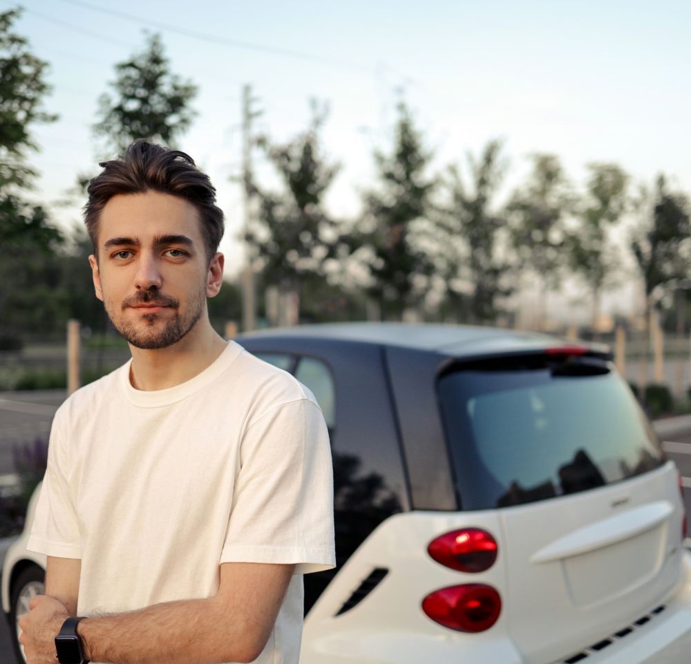 Student Driver standing next to smart car