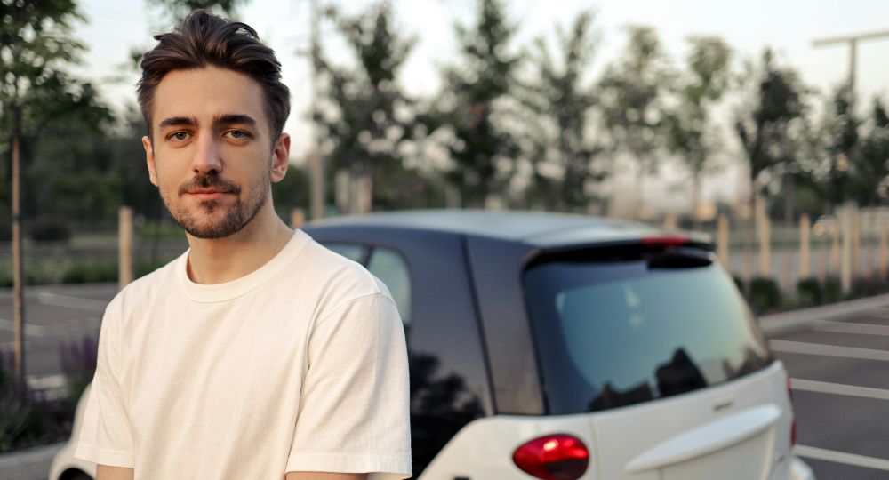Student Driver standing next to smart car