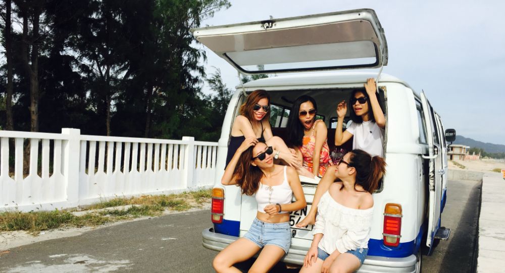 Group of people in the back of a van while on a road trip