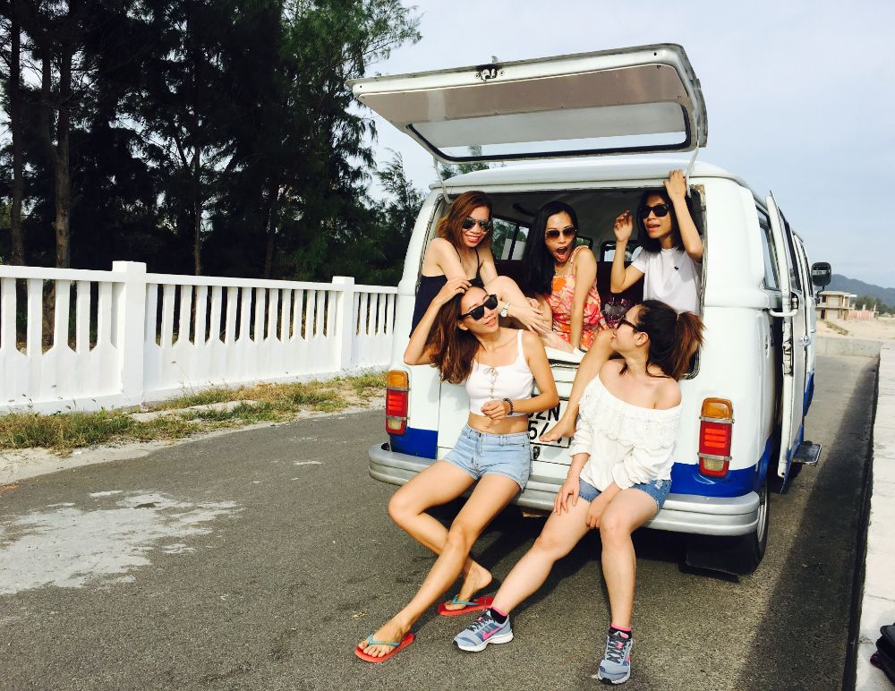 Group of people in the back of a van while on a road trip