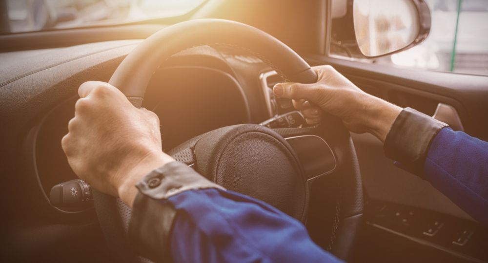 Close up of person's hands on steering wheel