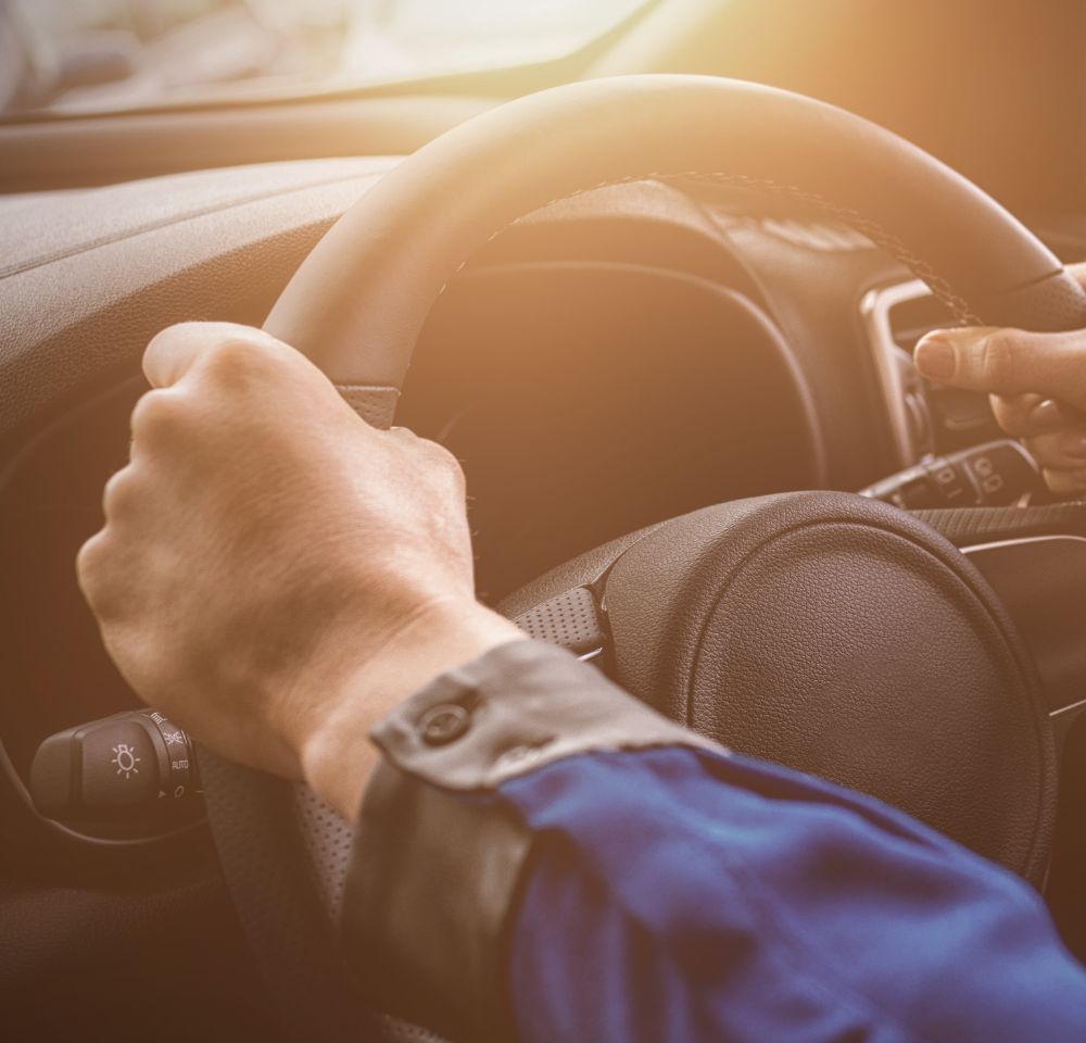 Close up of person's hands on steering wheel