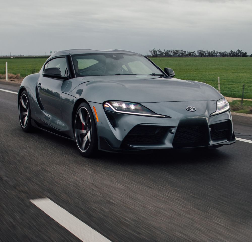 Grey performance car driving down road