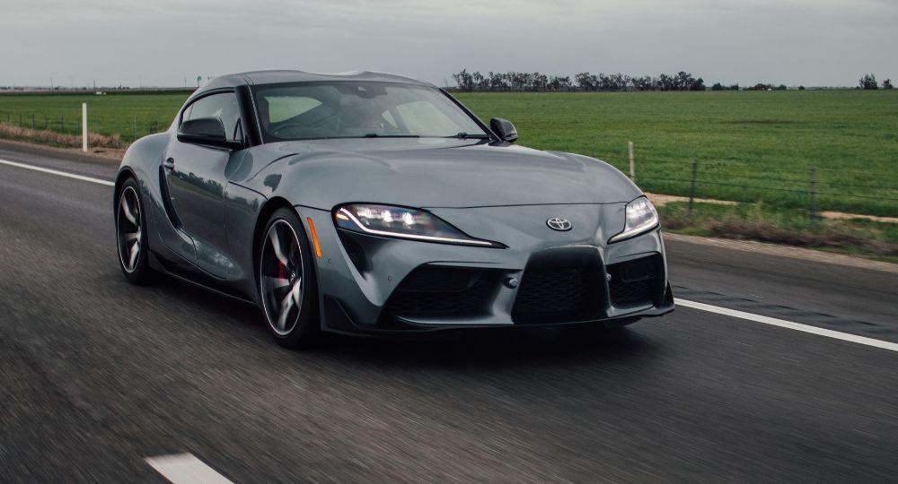 Grey performance car driving down road