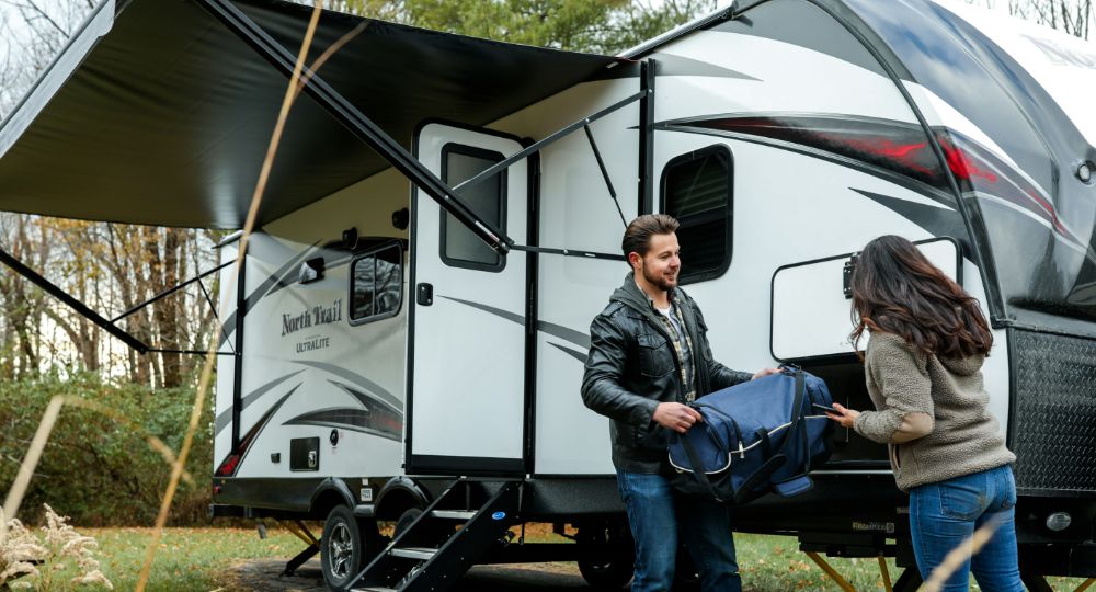 Couple outside of a large caravan
