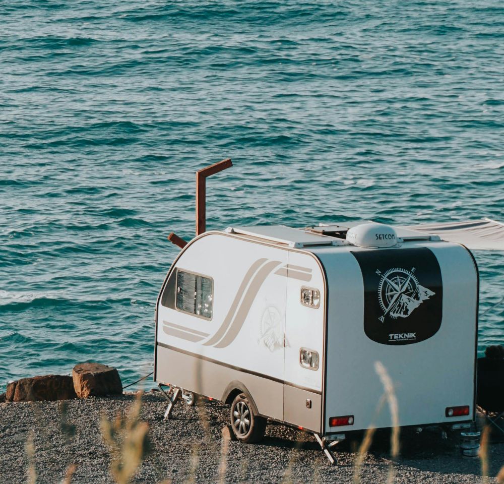 Small caravan parked next to the sea