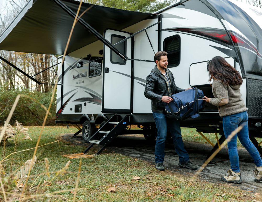 Couple outside of a large caravan