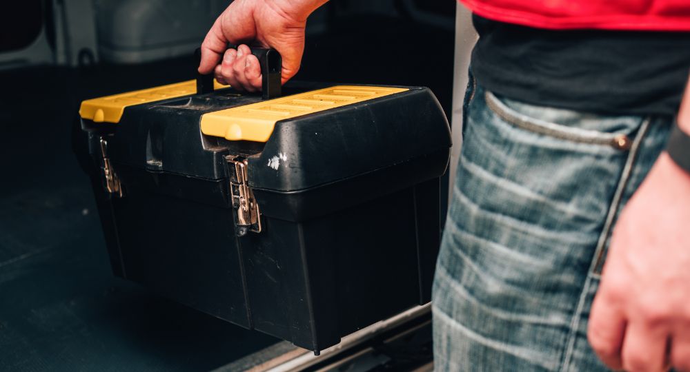 Person pulling tool box out of van