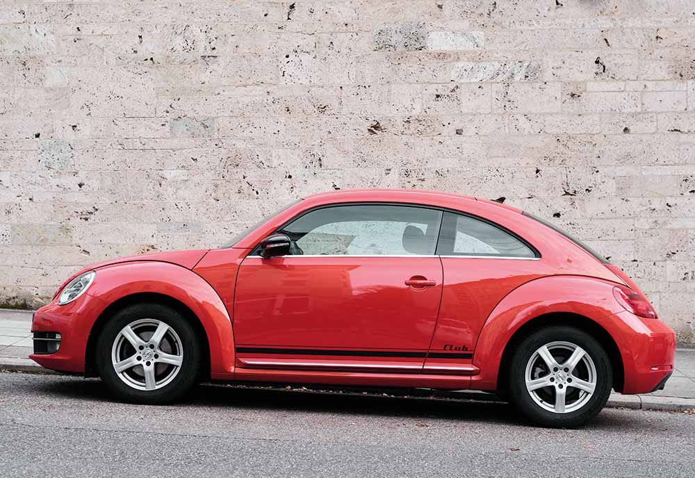 Red VW Beetle parked on the side of the road
