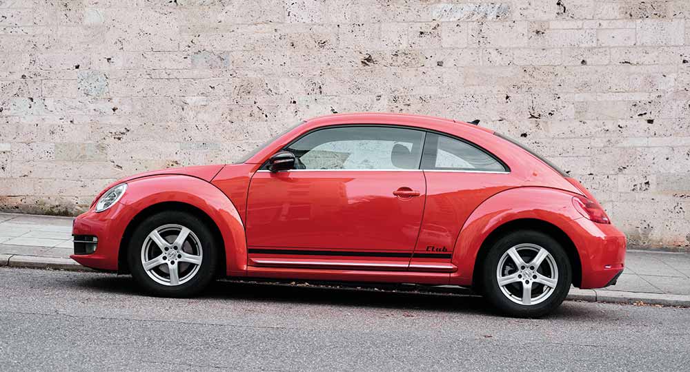 Red VW Beetle parked on the side of the road